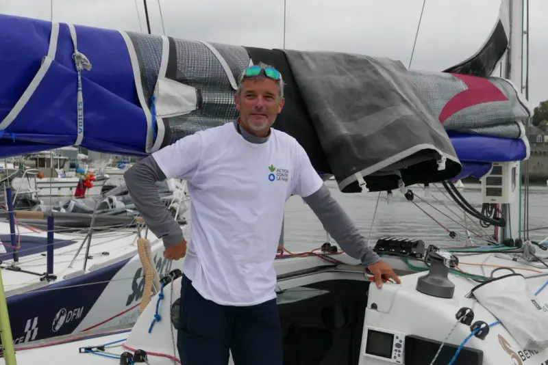 Gildas Mahé, skipper, pose sur son voilier, prêt pour une nouvelle aventure maritime.