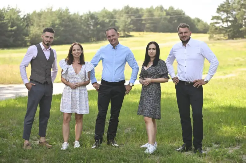 Uczestnicy programu "Rolnik szuka żony 10" pozują na tle zielonej łąki.