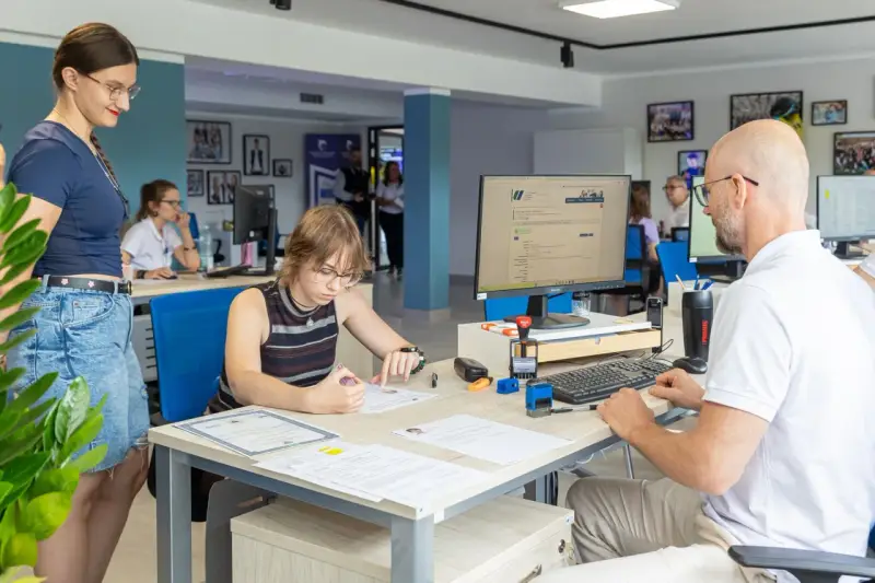 Studentka wypełnia dokumenty w biurze Zachodniopomorskiego Uniwersytetu Technologicznego w Szczecinie.