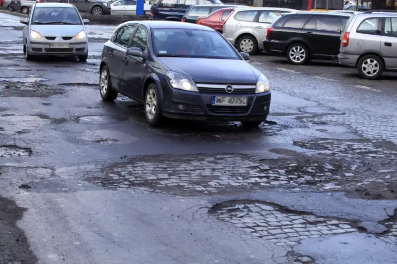 Samochody jadą po dziurawej drodze. Czy warto wykupić ubezpieczenie Europa Ubezpieczenia opinie?