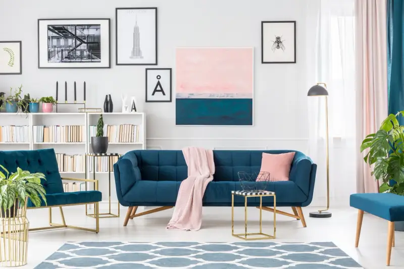 Granatowa sofa i fotele z pudrowym różem tworzą elegancką przestrzeń.
