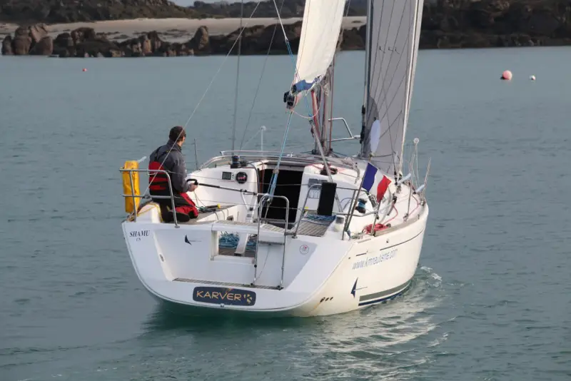 Un voilier Dufour 325 Grand Large navigue, un homme à la barre. Avis de navigation en mer.