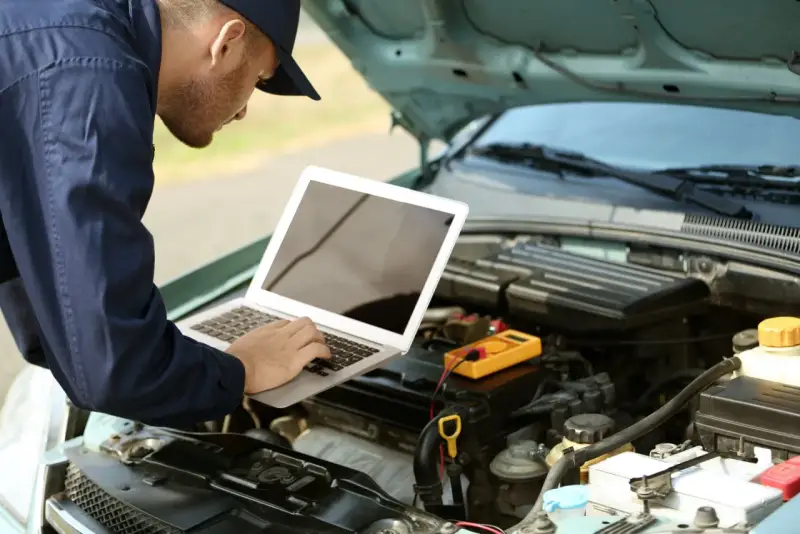 Mechanik diagnozuje usterkę w Oplu p2279, używając laptopa i multimetru.