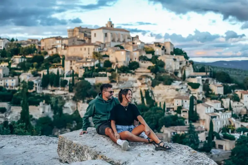 Couple en pause lors d'une randonnée à Gordes, profitant de la vue sur le village perché.