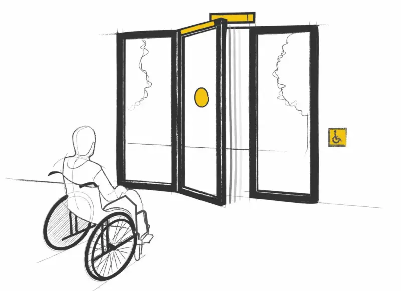 Persona en silla de ruedas se acerca a puertas automáticas, cumpliendo la normativa de puertas de portales para accesibilidad.