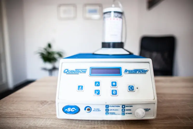 Urządzenie QuinTron BreathTracker do analizy oddechu na stole.