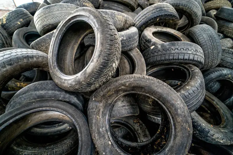 Stare opony czekają na nowe życie. Zastanawiasz się, co zrobić ze starymi oponami? Oto stos używanych opon samochodowych, gotowych do recyklingu lub kreatywnego wykorzystania.