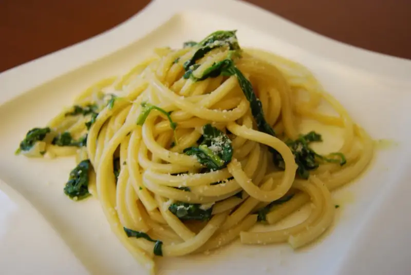 Bucatini z zielonymi liśćmi i parmezanem, pyszne danie, które może konkurować ze spaghetti.