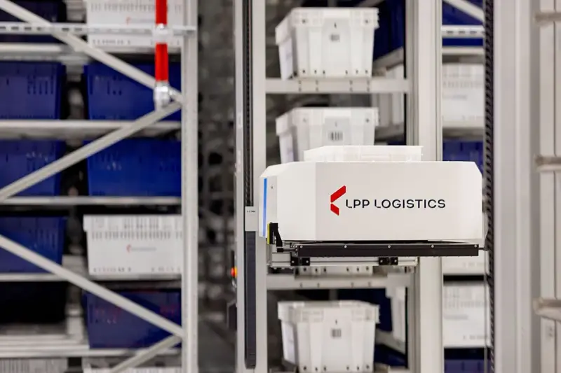 Automatyczny wózek w magazynie LPP Logistics pobiera pojemniki. System psi wms usprawnia pracę.