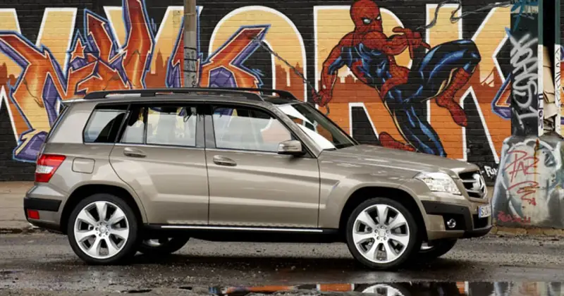 Brązowy suv Mercedes GLK na tle kolorowego graffiti z Spider-Manem.