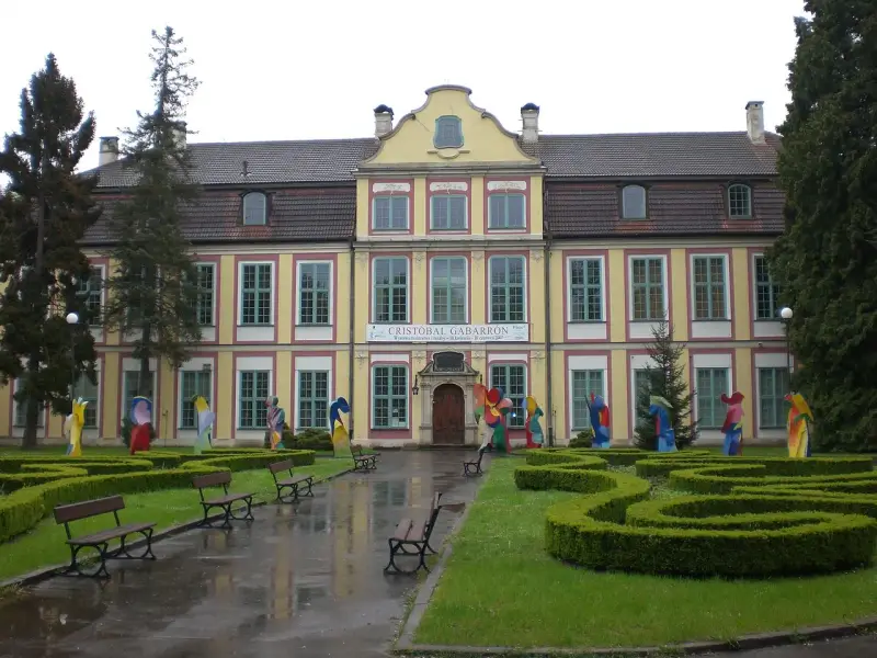 Pałac Opatów zaprasza na wystawę Cristobala Gabarrona. Kolorowe rzeźby zdobią dziedziniec przed zabytkowym budynkiem.