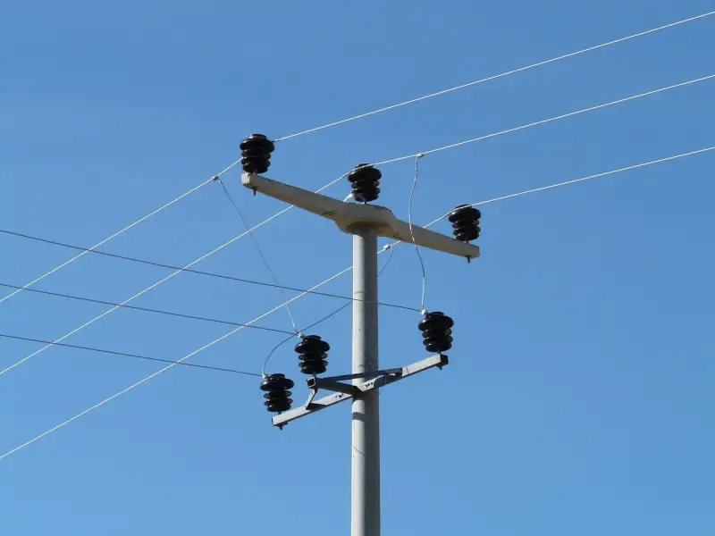 Słup energetyczny z izolatorami, na którym widać przewody elektryczne. Taryfa B23 może być związana z takim właśnie zasilaniem.