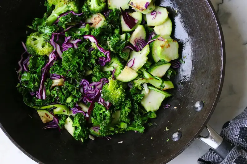 Grönkål, broccoli och rödkål i en wok. Ett härligt sallad recept för en hälsosam måltid.