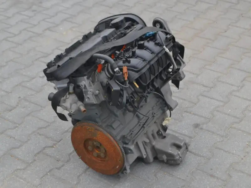 Silnik Alfa Romeo 156, gotowy do montażu. Widoczny koło zamachowe i elementy układu dolotowego.