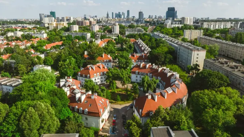 Zielony Żoliborz Oficerski z charakterystyczną architekturą i panoramą miasta w tle.