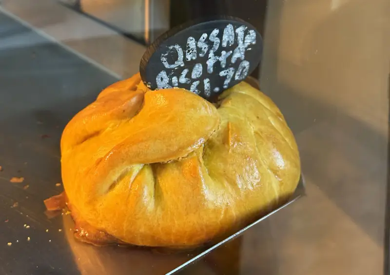 Złociste, pieczone ciasto z nadzieniem, typowe maltańskie jedzenie. Na tabliczce napis "Cassata Ricotta €1.70".