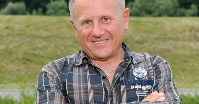 Uśmiechnięty mężczyzna w kratę, z krzyżykiem na szyi. To Bercik, znany z serialu.