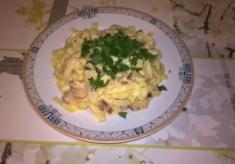 Pyszne fettuccine z boczkiem i pieczarkami, polane kremowym sosem. Idealna odpowiedź na pytanie: jaka śmietana do carbonary?