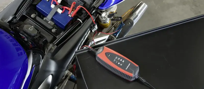 Caricabatterie collegato alla batteria di una moto. Un modo semplice per **come ricaricare le batterie** e ripartire.
