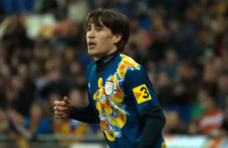 Bojan Krkić w akcji, jego bojan krkić statystyki są imponujące. Piłkarz w niebieskiej koszulce z żółtym wzorem.