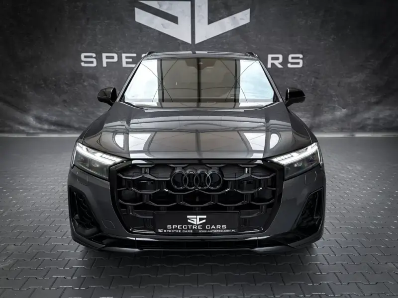 Przód ciemnoszarego Audi Q7 z czarnym grillem i światłami LED.