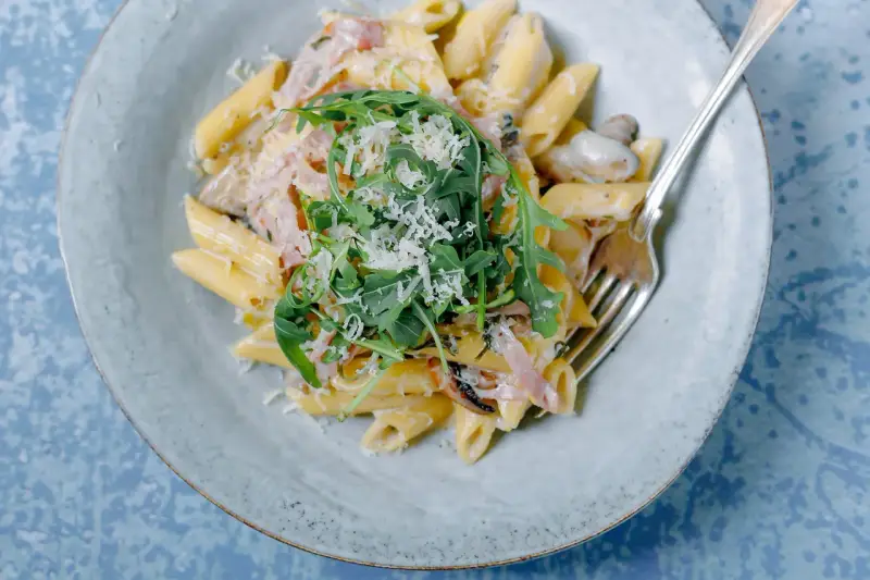 Penne rigate w kremowym sosie z rukolą i parmezanem. Idealne do zatrzymywania sosu, w przeciwieństwie do gładkiego makaronu penne lisce.