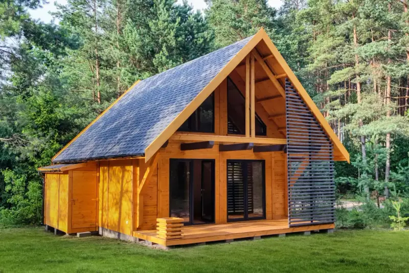 Nowy, drewniany dom letniskowy gotowy do zamieszkania, otoczony zielenią lasu.