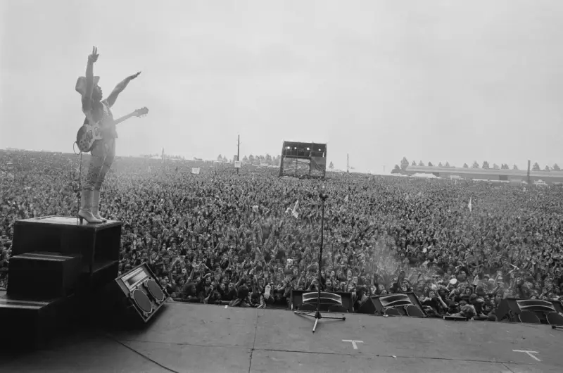 Ogromny tłum na koncercie Metallica Moskwa 1991. Wokalista na scenie, ręce w górze, wita fanów.