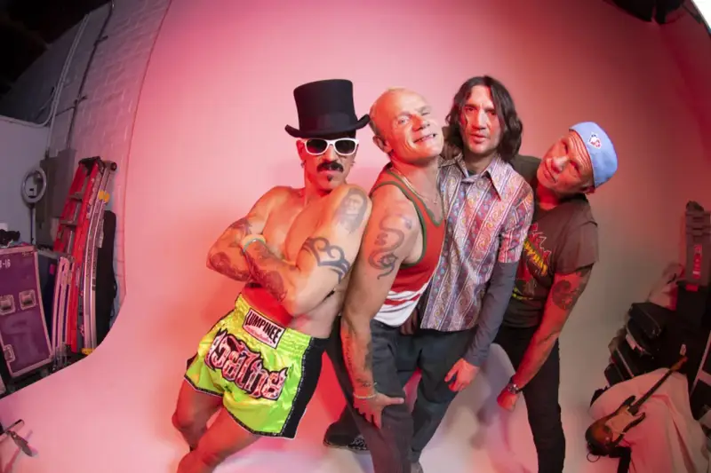 Les membres de Red Hot Chili Peppers posent ensemble, un groupe de rock iconique.