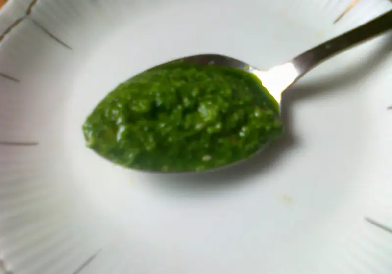 Łyżeczka pełna aromatycznego pesto z pietruszki, gotowa do podania.