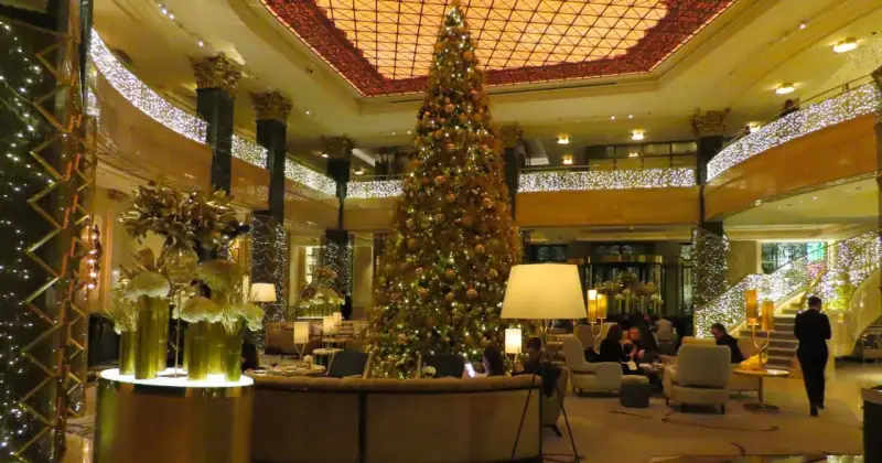 Elegancka wigilia w hotelu. Ogromna choinka i złote dekoracje tworzą świąteczną atmosferę.