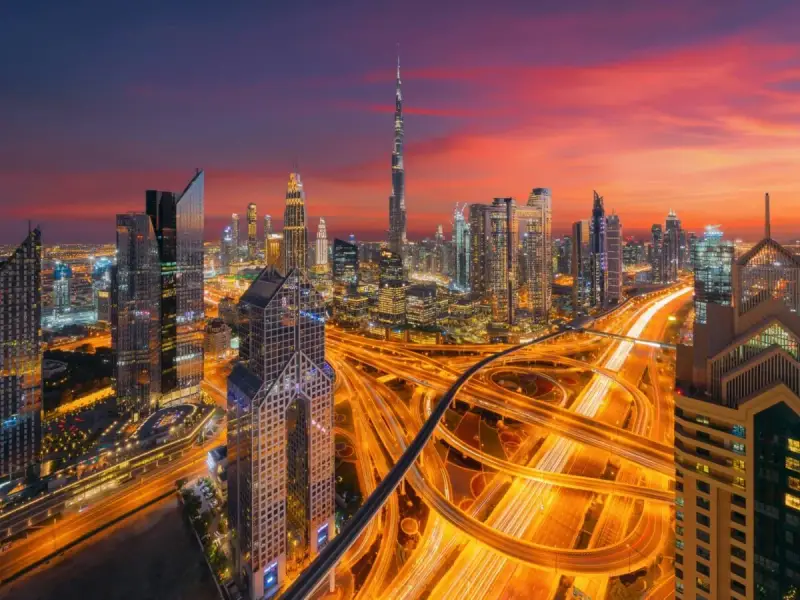 Wieczorny widok na Dubaj z drapaczami chmur i autostradą. W tle widać Burdż Chalifa. To miasto, gdzie kwitnie handel i **waluta Dubaju** jest symbolem rozwoju.
