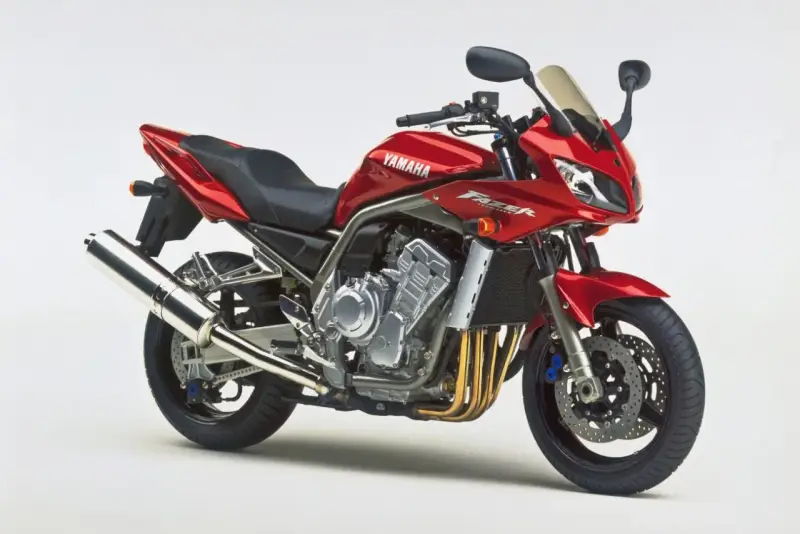 Czerwony motocykl Yamaha Fazer 1000, z widocznym silnikiem i wydechem. Choć piękny, warto pamiętać o jego potencjalnych wadach.