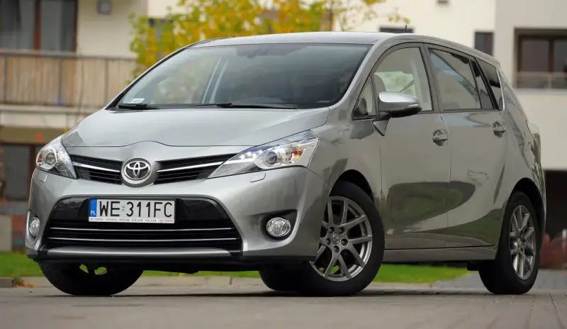 Srebrna Toyota Verso 1.8 benzyna zaparkowana przed domem.