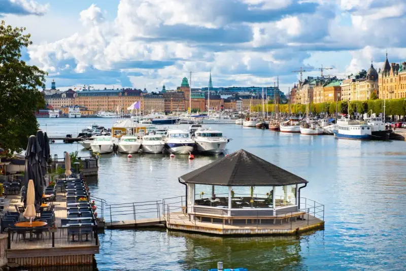 Widok na port w Sztokholmie, z łodziami i budynkami w tle. To jedno z szwecja najpiękniejsze miejsca.