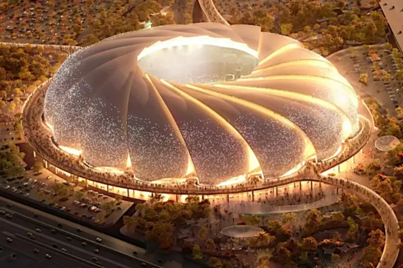 Futurystyczny stadion, który może być najładniejszy na świecie, z falującym dachem i oświetlonymi detalami, otoczony zielenią i tłumem ludzi.