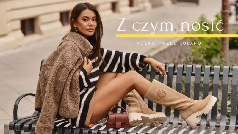 Kobieta w beżowych kozakach przed kolano, w stylizacji z kamizelką i sukienką w paski, pokazuje, z czym nosić kozaki przed kolano.