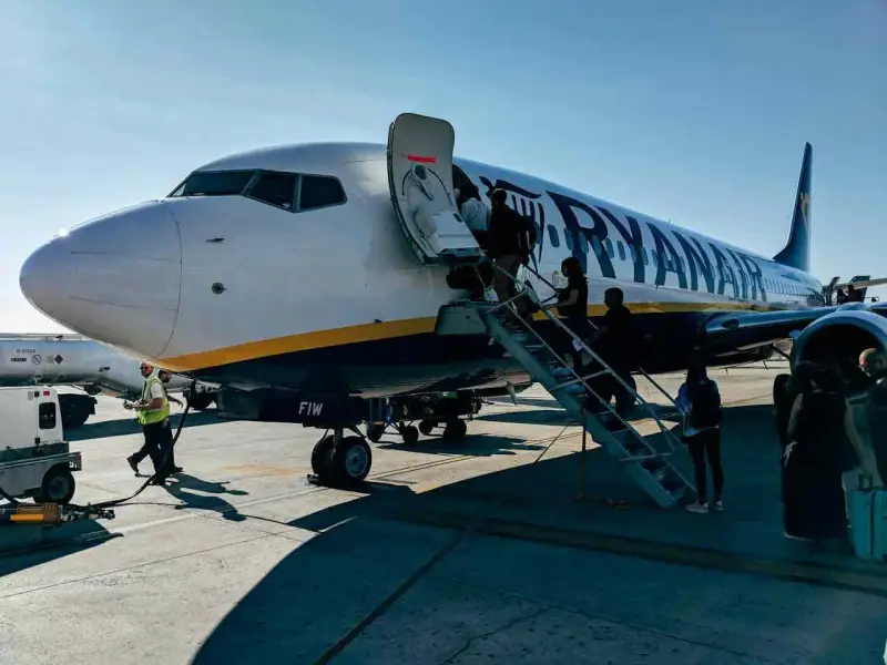 Ryanair samolot, pasażerowie wsiadają. Pamiętaj o zasadach, jak przewozić leki w samolocie Ryanair, by podróż przebiegła sprawnie.