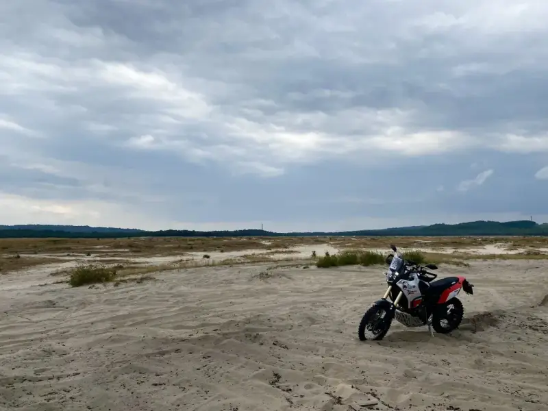 Motocykl na piaszczystym terenie, idealny na szlak Orlich Gniazd samochodem trasę.