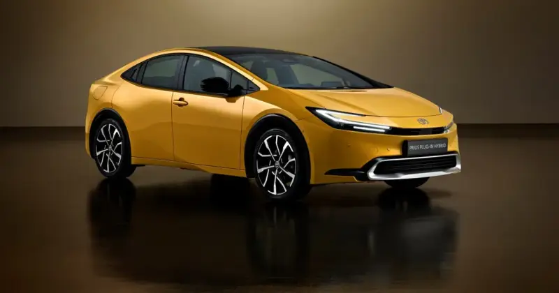 Złoty Toyota Prius Plug-in Hybrid z czarnym dachem, nowoczesnymi światłami i stylowymi felgami.