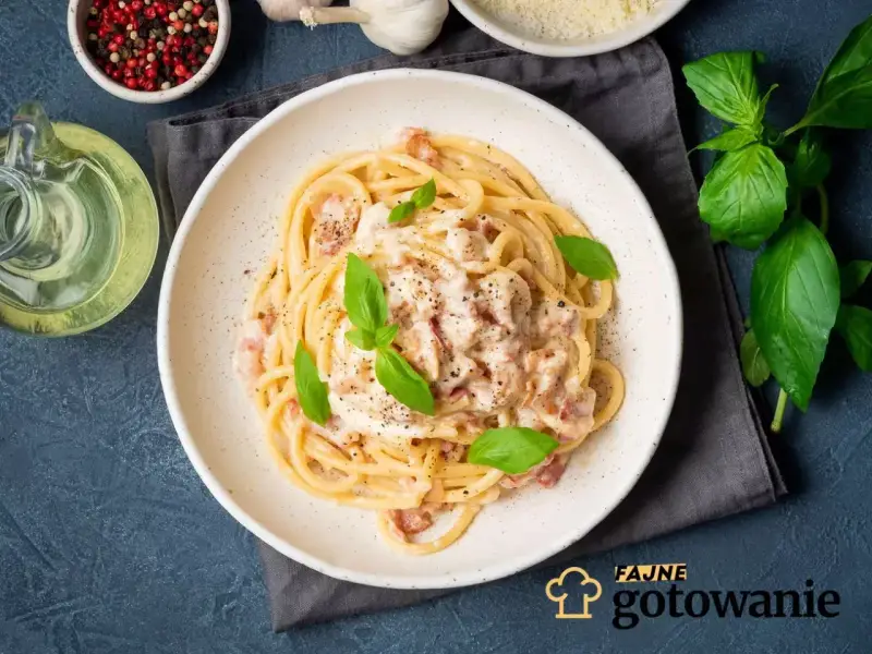 Pyszna carbonara na talerzu, idealna inspiracja, jak zrobić carbonare. Podana z bazylią i pieprzem.