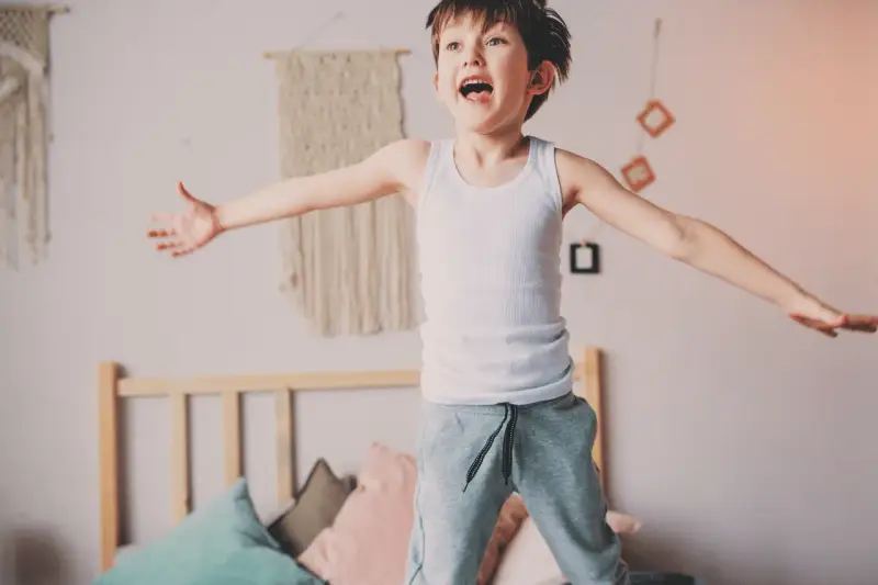 Bambino iperattivo 4 anni cosa fare? Un bimbo salta sul letto, pieno di energia.