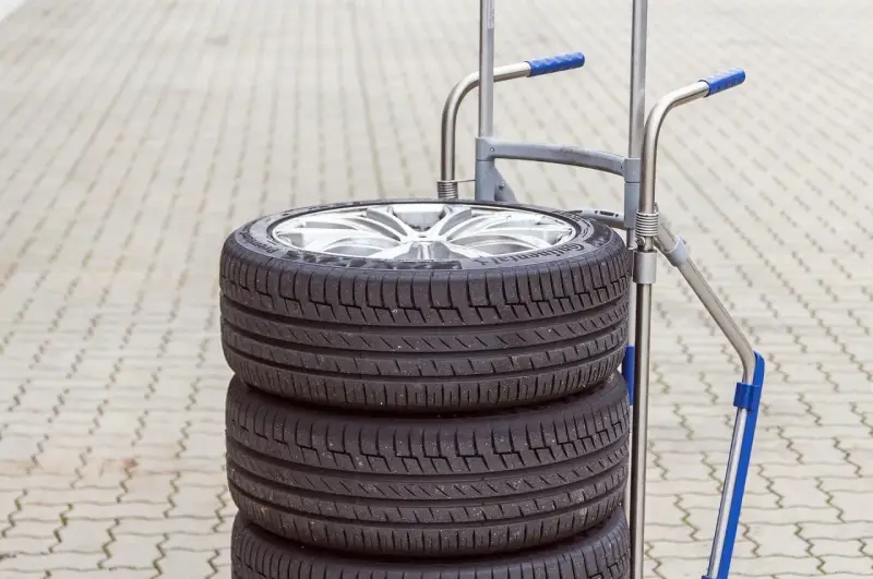 Stos czterech opon samochodowych na wózku. Zastanawiasz się, ile waży opona samochodowa?
