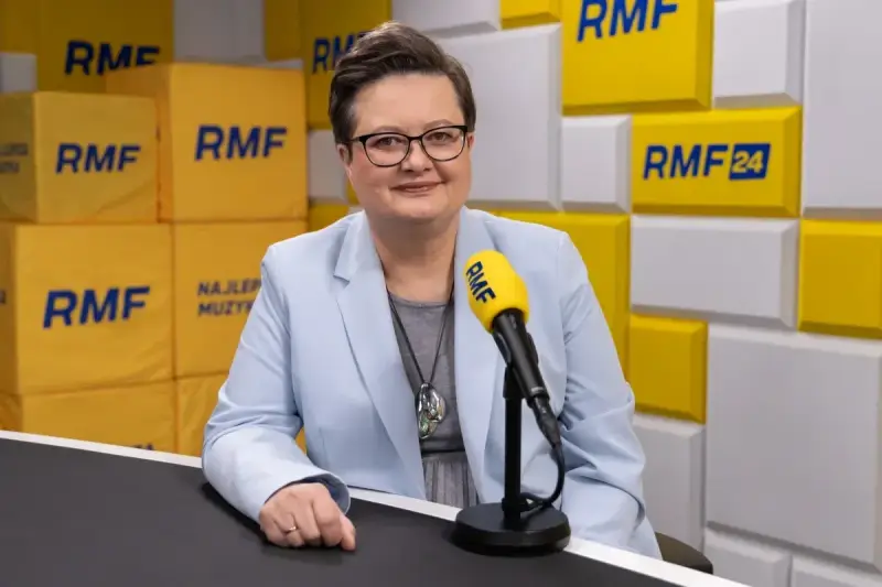Minister edukacji w jasnej marynarce przed mikrofonem RMF FM.