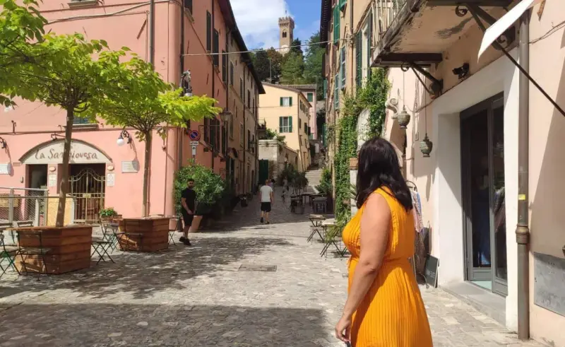 Un vicolo pittoresco con un campanile in lontananza, perfetto per scoprire cosa vedere vicino Rimini.