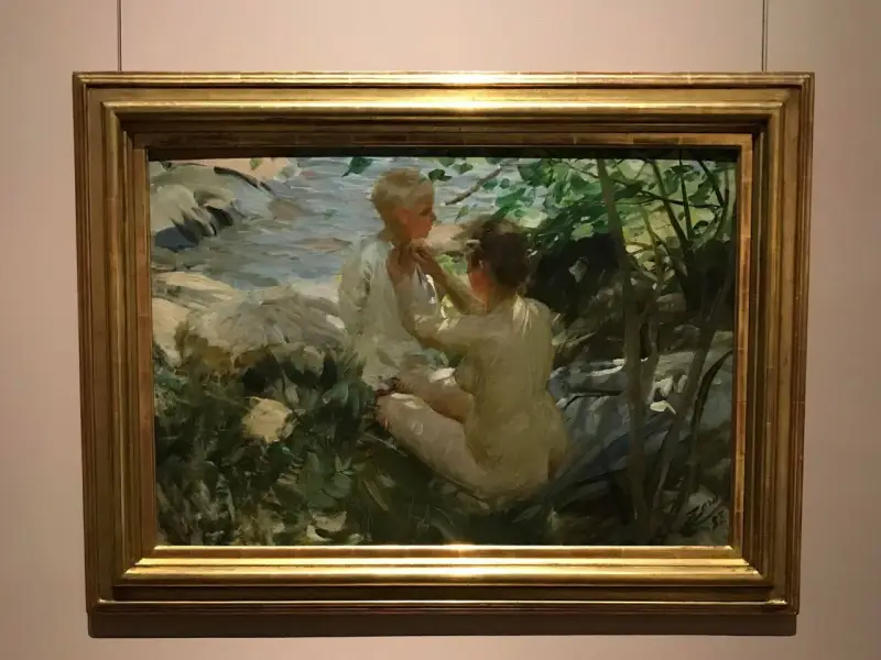 Anders Zorn fångar två barn vid en bäck. En flicka klär på en pojke i solljus.