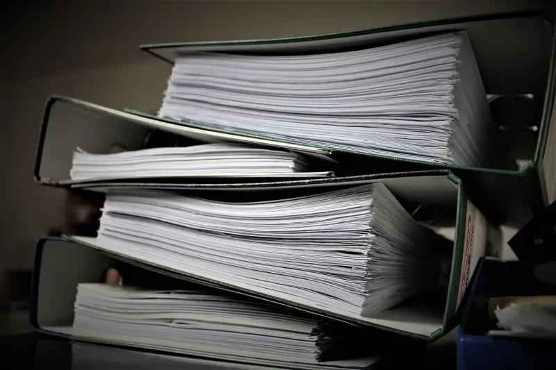 Stosy dokumentów w segregatorach. Może to być materiał do analizy, ale też dowód na to, że popełniono błąd i teraz potrzebny jest czynny żal.