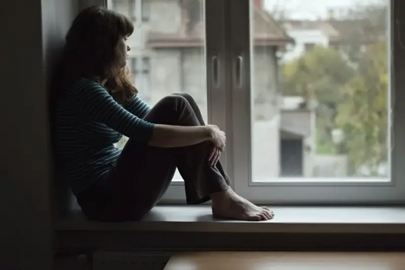 Dziewczyna siedzi na parapecie, patrząc przez okno. Czy to melancholia co to? Smutek i zaduma w jej oczach.