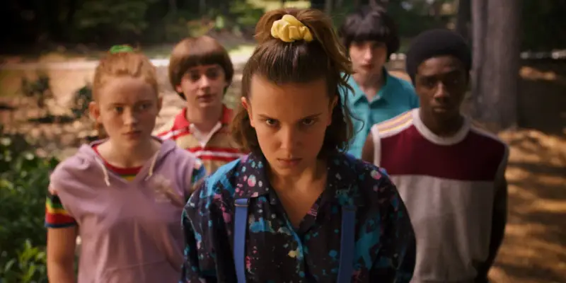 Die Gruppe aus Stranger Things, bereit für ein Abenteuer, während die ikonische Stranger Things Musik im Hintergrund spielt.