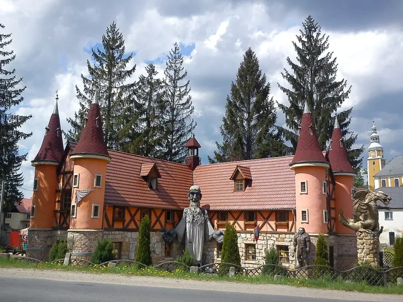 Zamek śląskich legend z wieżyczkami i kamiennymi rzeźbami.